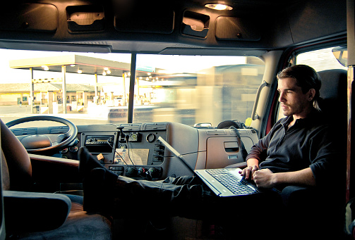 a man with his laptop inside a vehicle