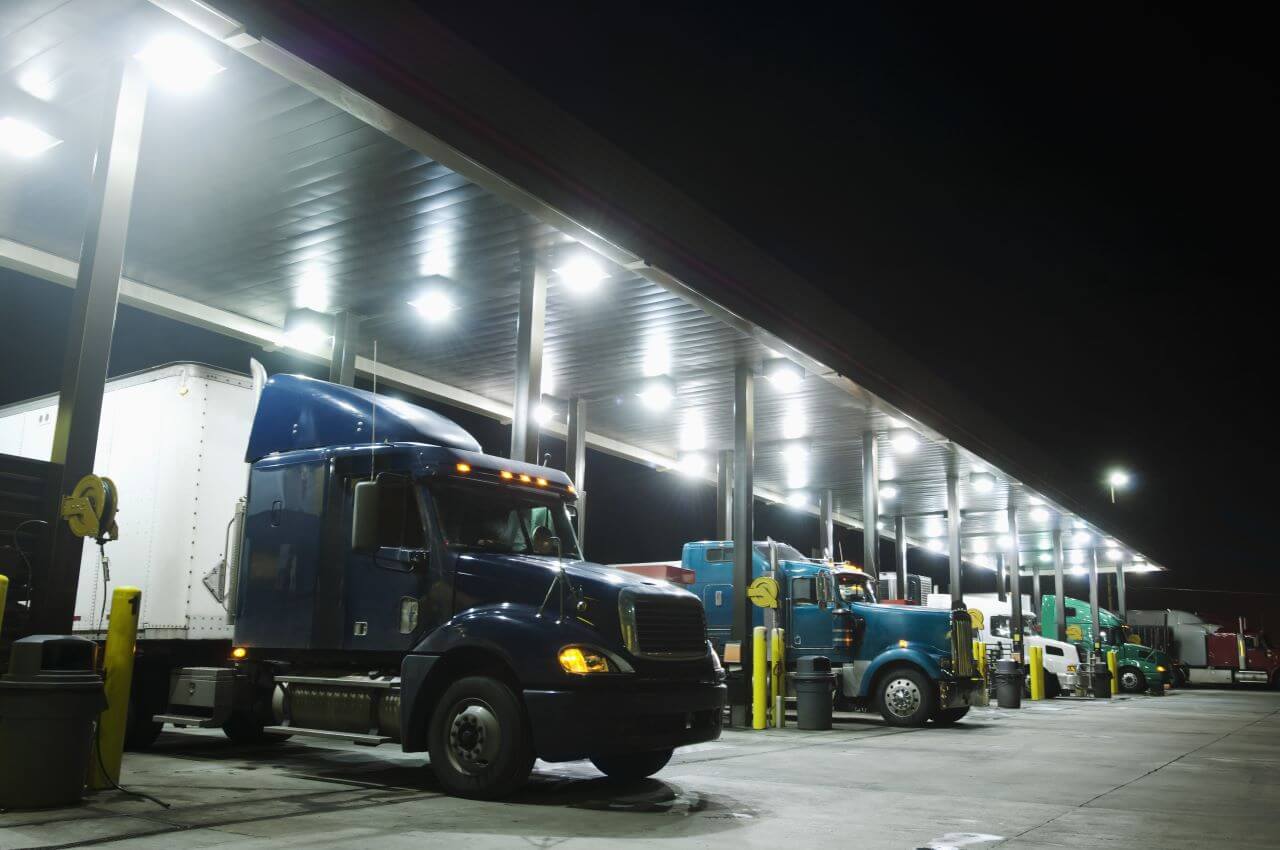 A group of trucks parked in a parking lot at night.